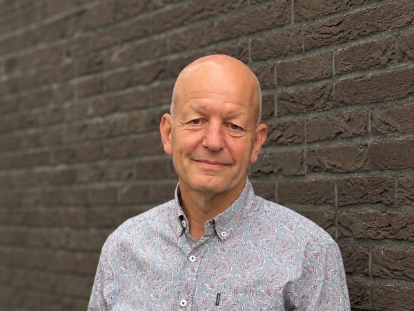 Vriendelijke portretfoto tegen bakstenen muur